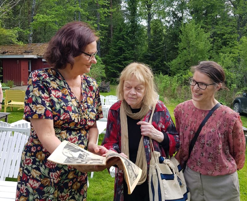 Ebba Witt Brattström, ordförande i Moas Vänner, Aase Fridegård och Kristina Sandberg studerar gamla tidningar med artiklar om Moa och Jan